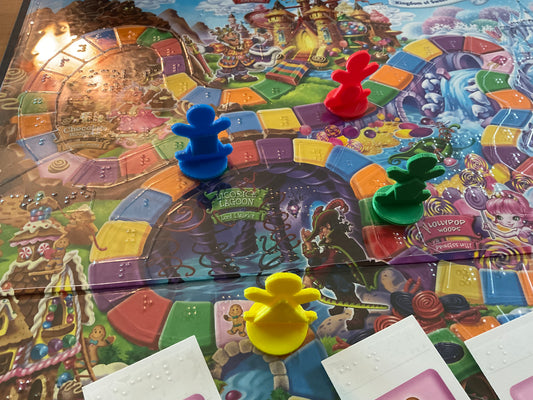 Close up on the 3d printed replacement pieces. The thermoformed overlay can be seen along with the braille on the spaces indicating the colors. Each replacement piece has a shape on it that corresponds to the color.