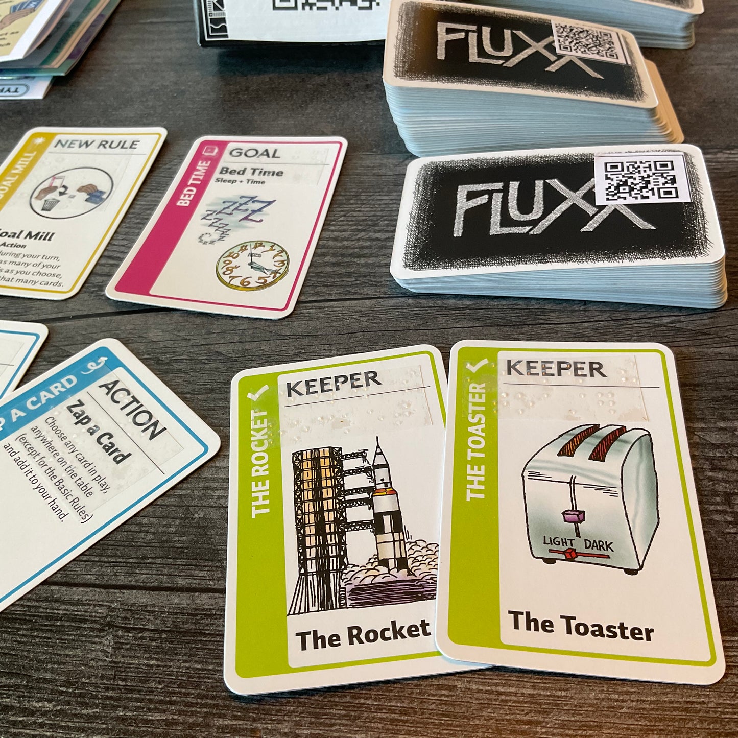 A close up on the keeper cards the rocket and toaster. The braille is transparent on the cards.