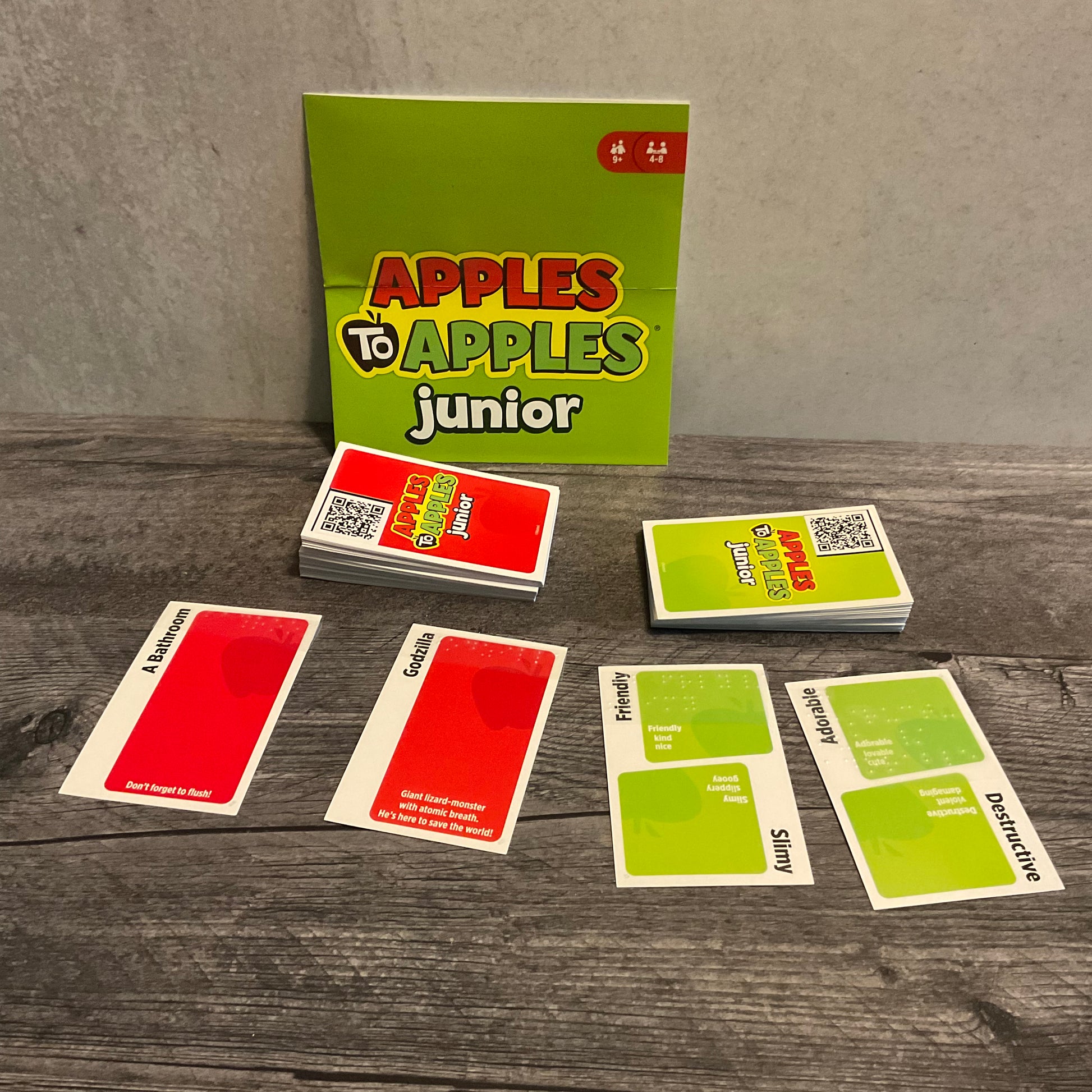 Apples to apple cards with QR code stickers on the back. The QR codes lead to the full text of the cards.