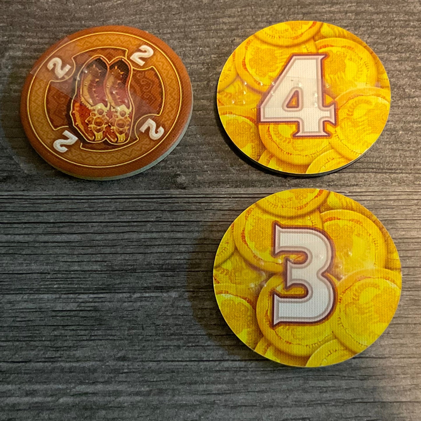 Brown tokens, showing both sides with transparent braille on them