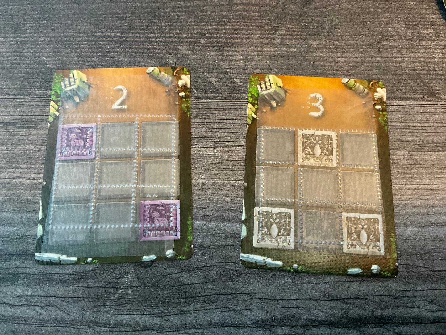 The cards showing the needed layouts tactilely and the point values awarded for completing them.