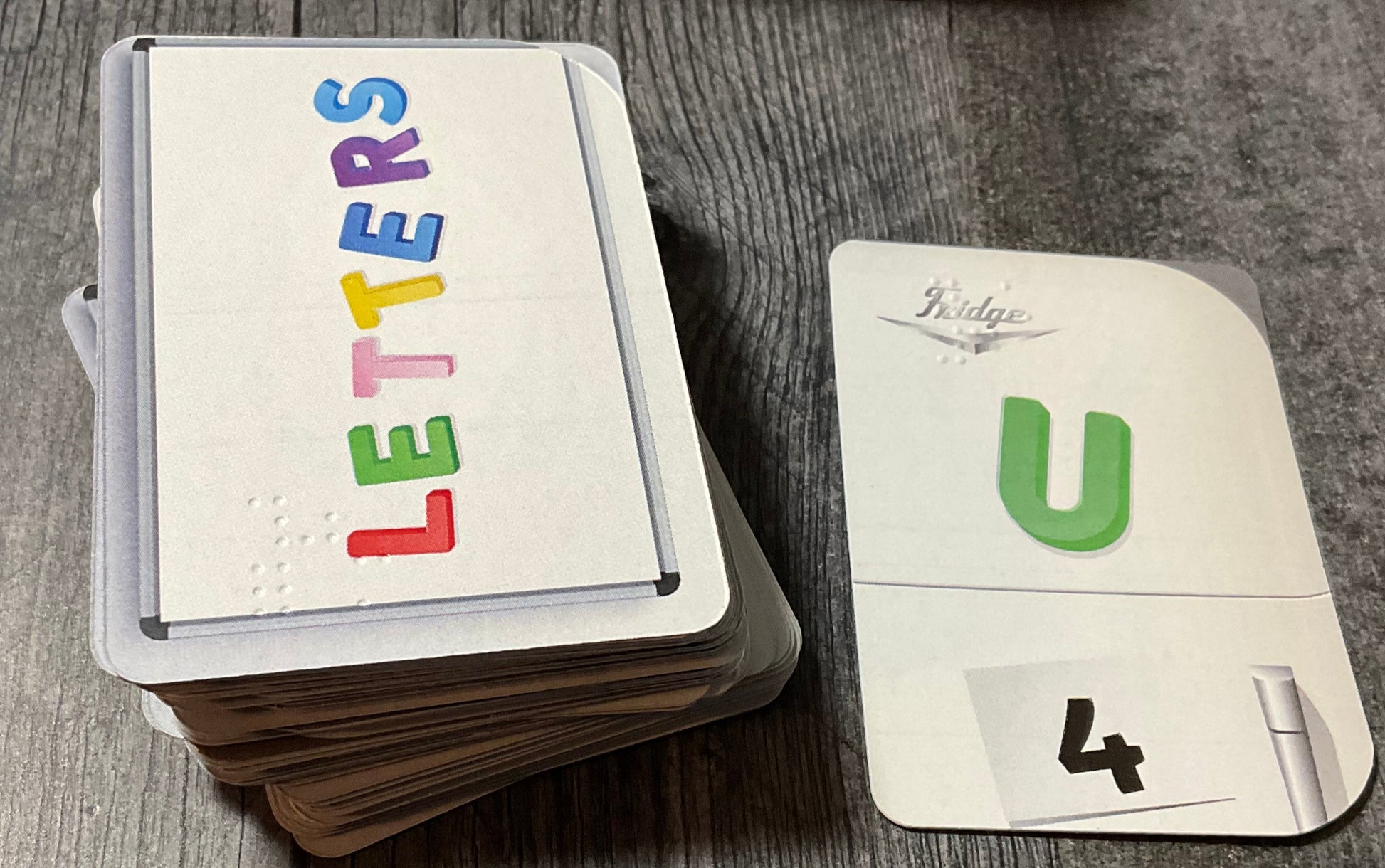 The Letters deck sitting next to a U flipped face up