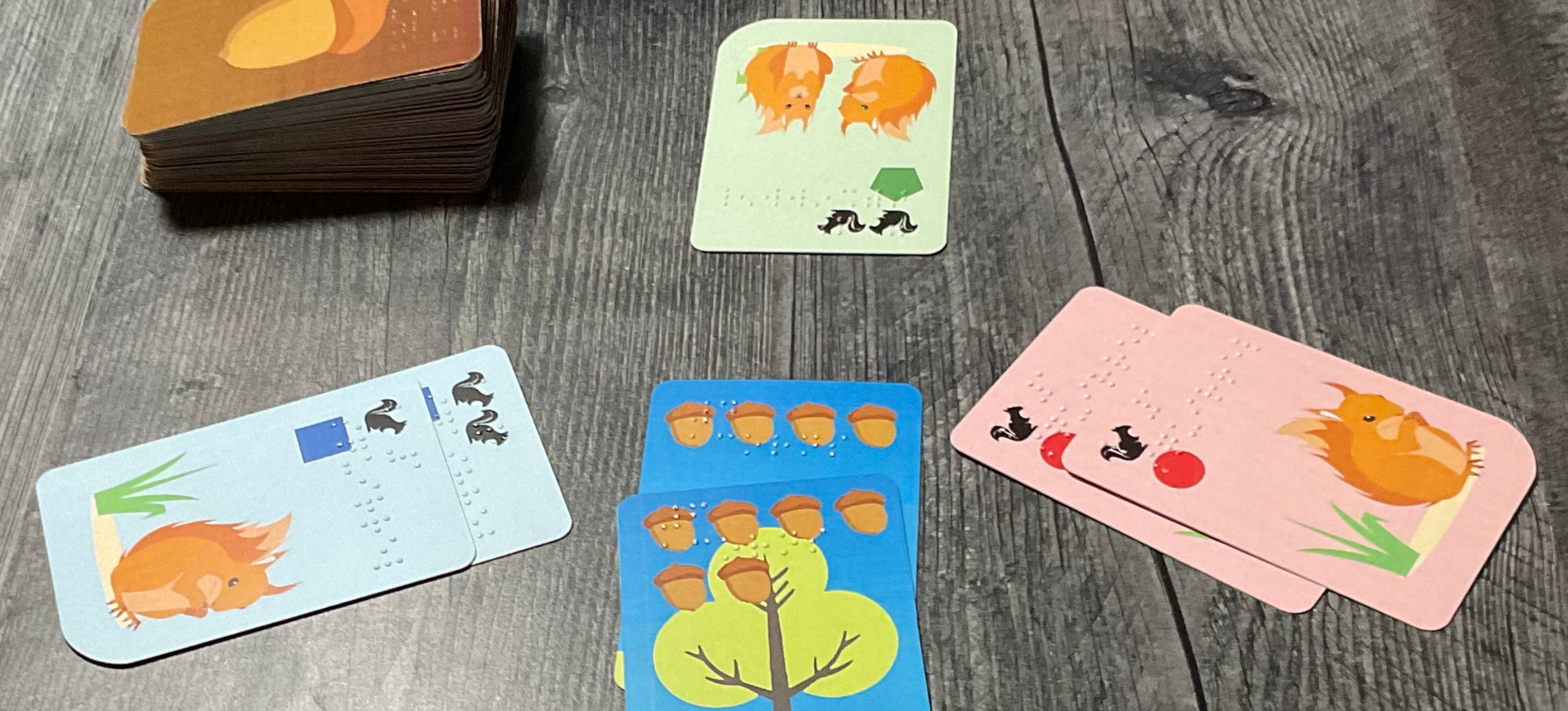 Three different players using the squirrel cards to surround a tree.