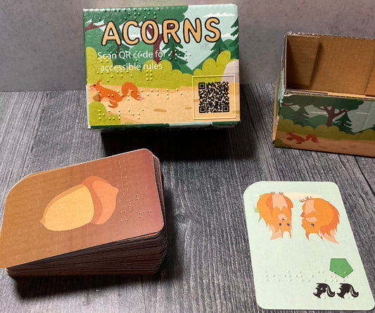 Picture of the Acorns box with the cards in front of it.