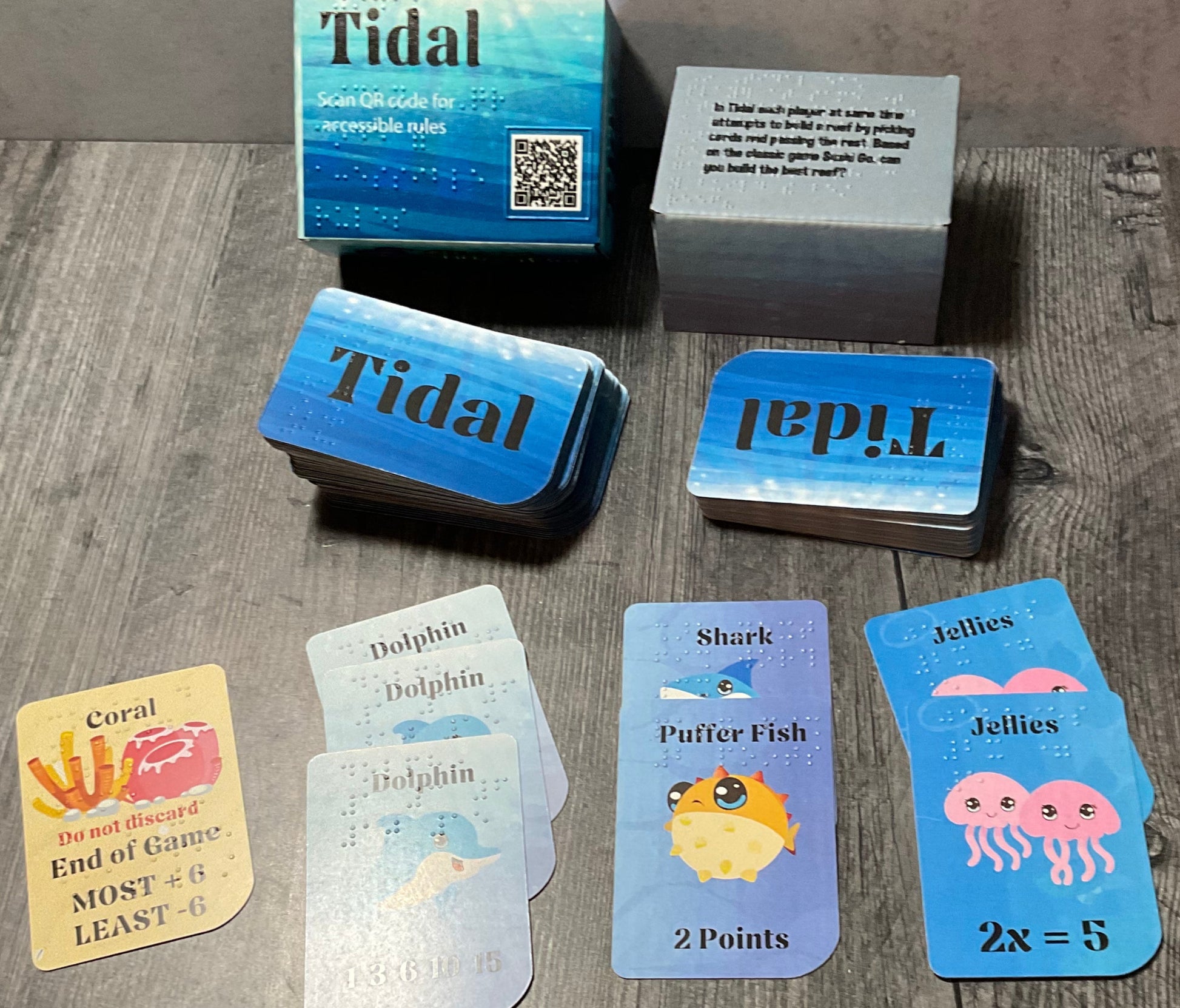 A picture of the Tidal box and some of the cards laid out in front. Coral, dolphins, Sharks, puffer fish and Jellies are shown.