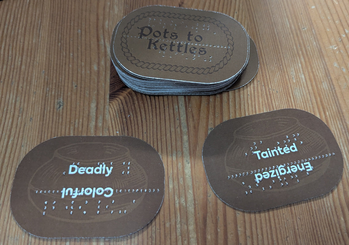 A stack of the kettle cards is shown. Each card has two words on them in both print and braille. This allows the judge to make a choice of which to use. They can be rotated so that the chosen side is face up.