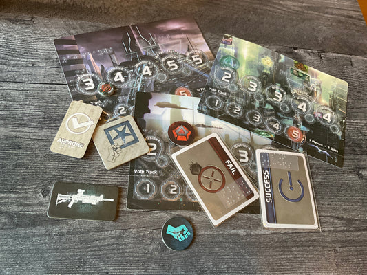 A bunch of the tokens and cards from the game laid out. all of the tokens and cards have transparent braille on them.