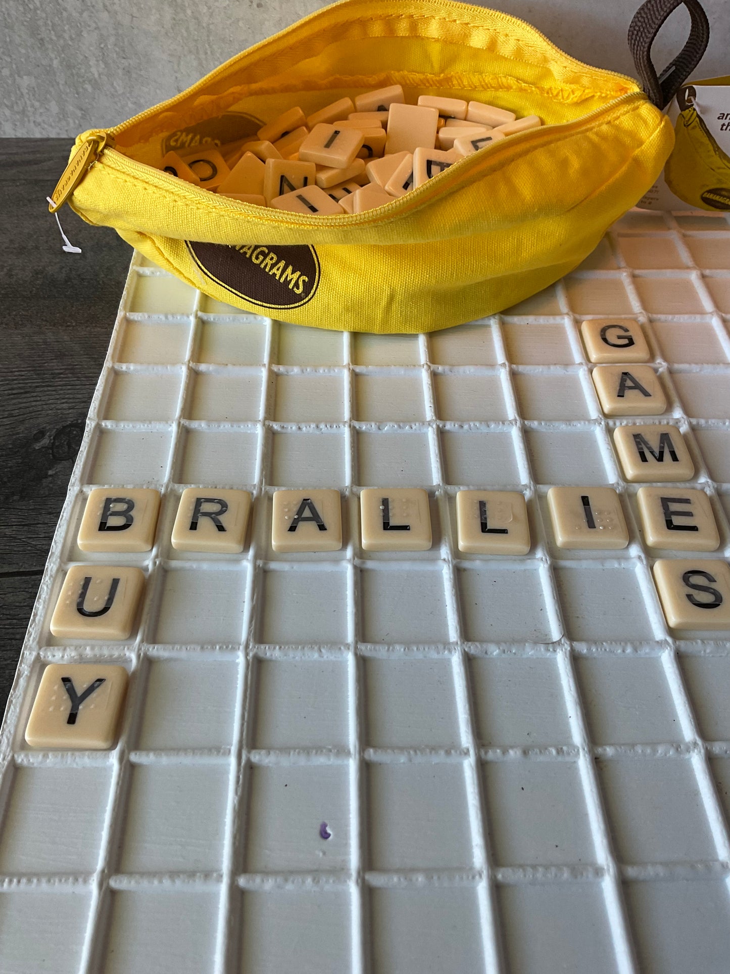 A picture of the tiles in the tray with the words "buy braille games" spelled out.