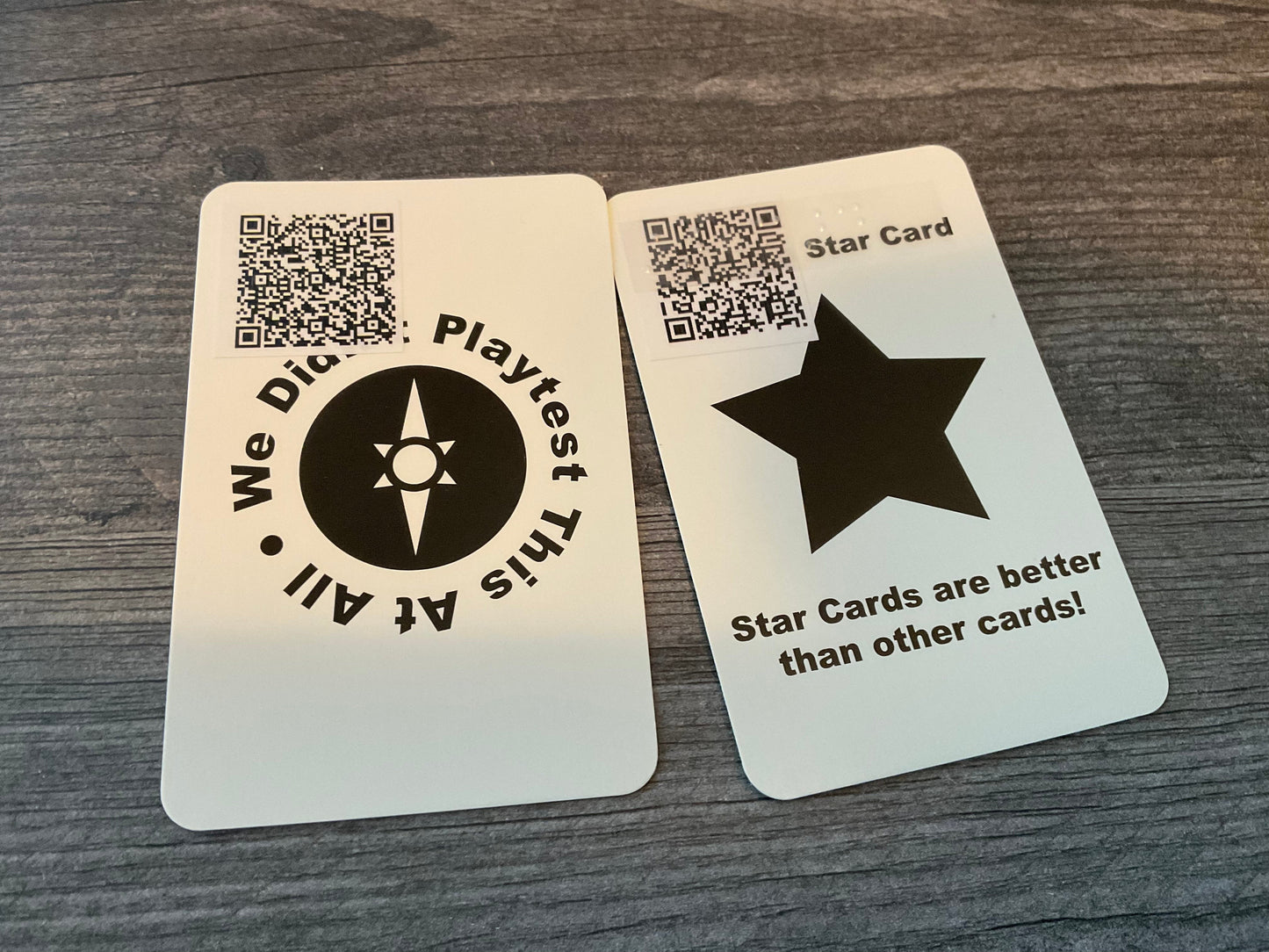 The back of two cards. They both have QR codes on them but the star card also has transparent braille on it saying star