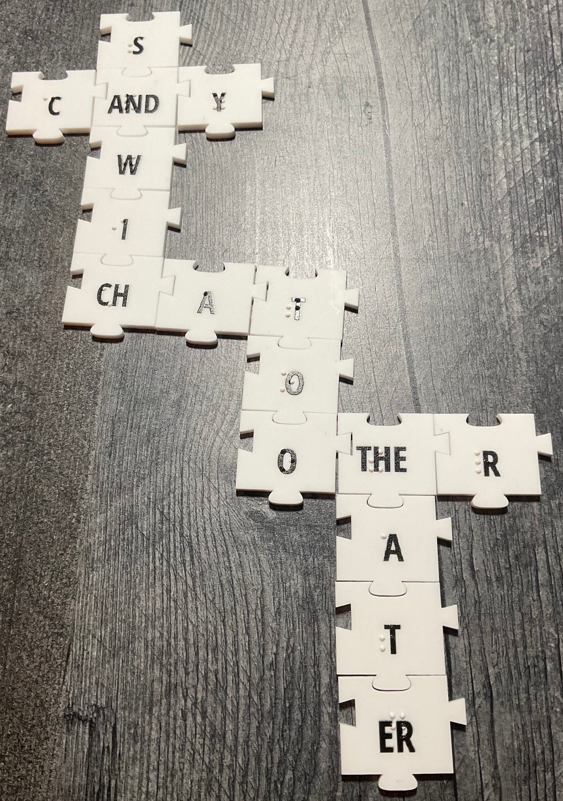 A picture of the tiles forming a cross grid. At the top CANDY and SANDWICH are spelled using the AND and CH contractions.  From the CH the word CHat is made with too attached to it vertically. The last O on too connects to OTHER which uses a THE contraction. Finally the THE contraction going downward spells THEATER with an ER sign.