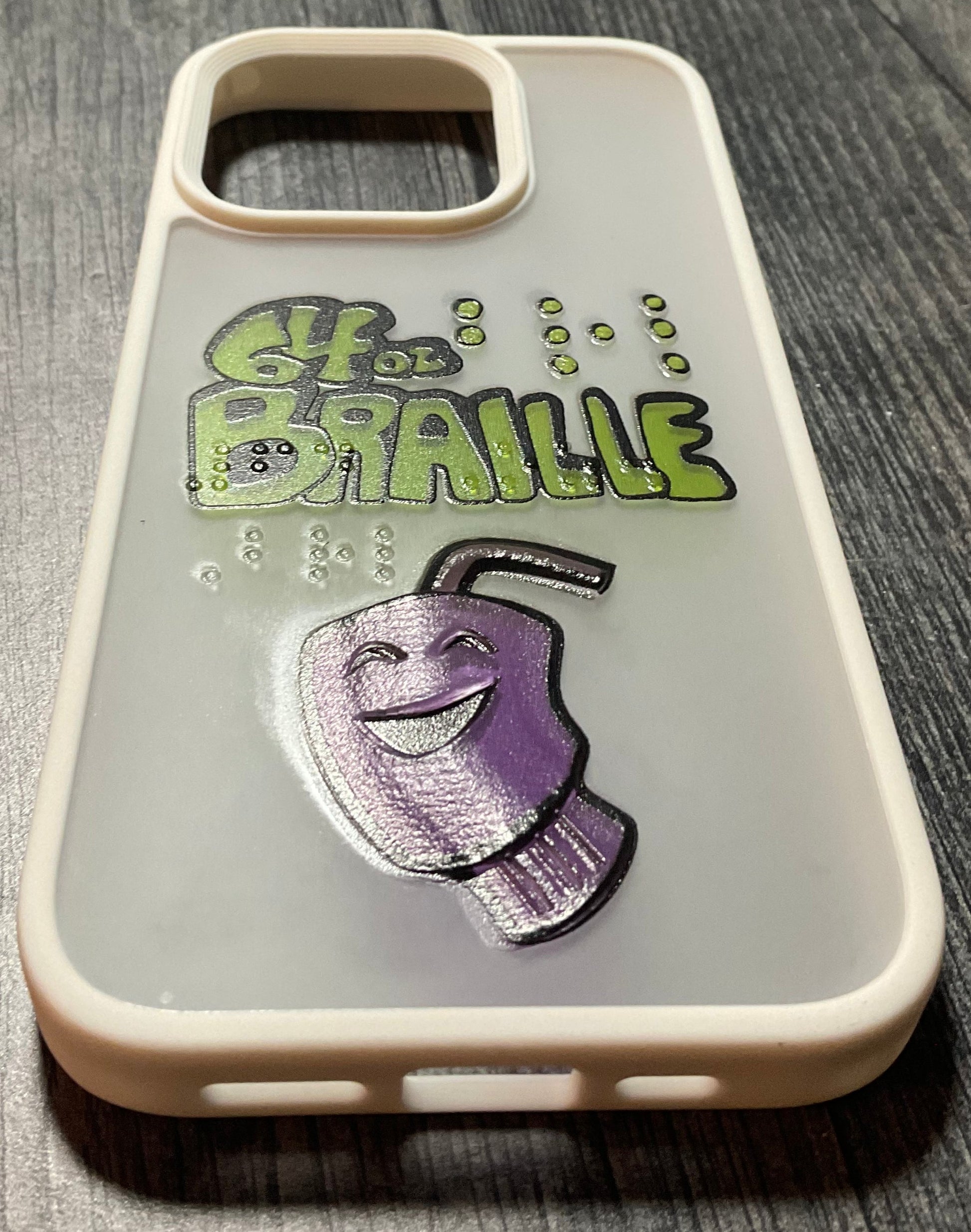 Cell phone case with the 64 Oz. Games logo. The words 64 oz. Braille are ion the phone in transparent braille along with a tactile version of our cup logo.