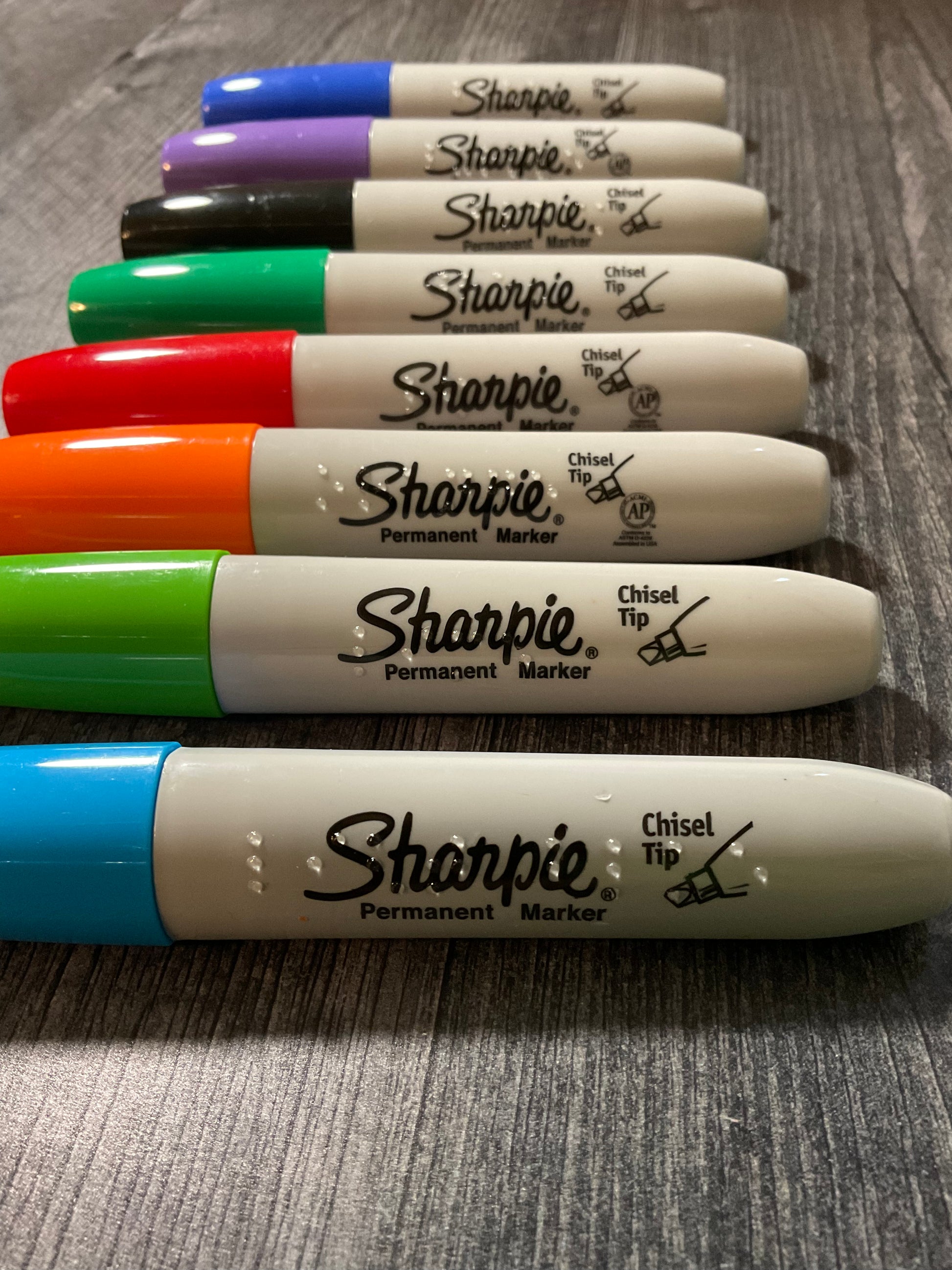 The 8 colors of sharpies with transparent braille on them.