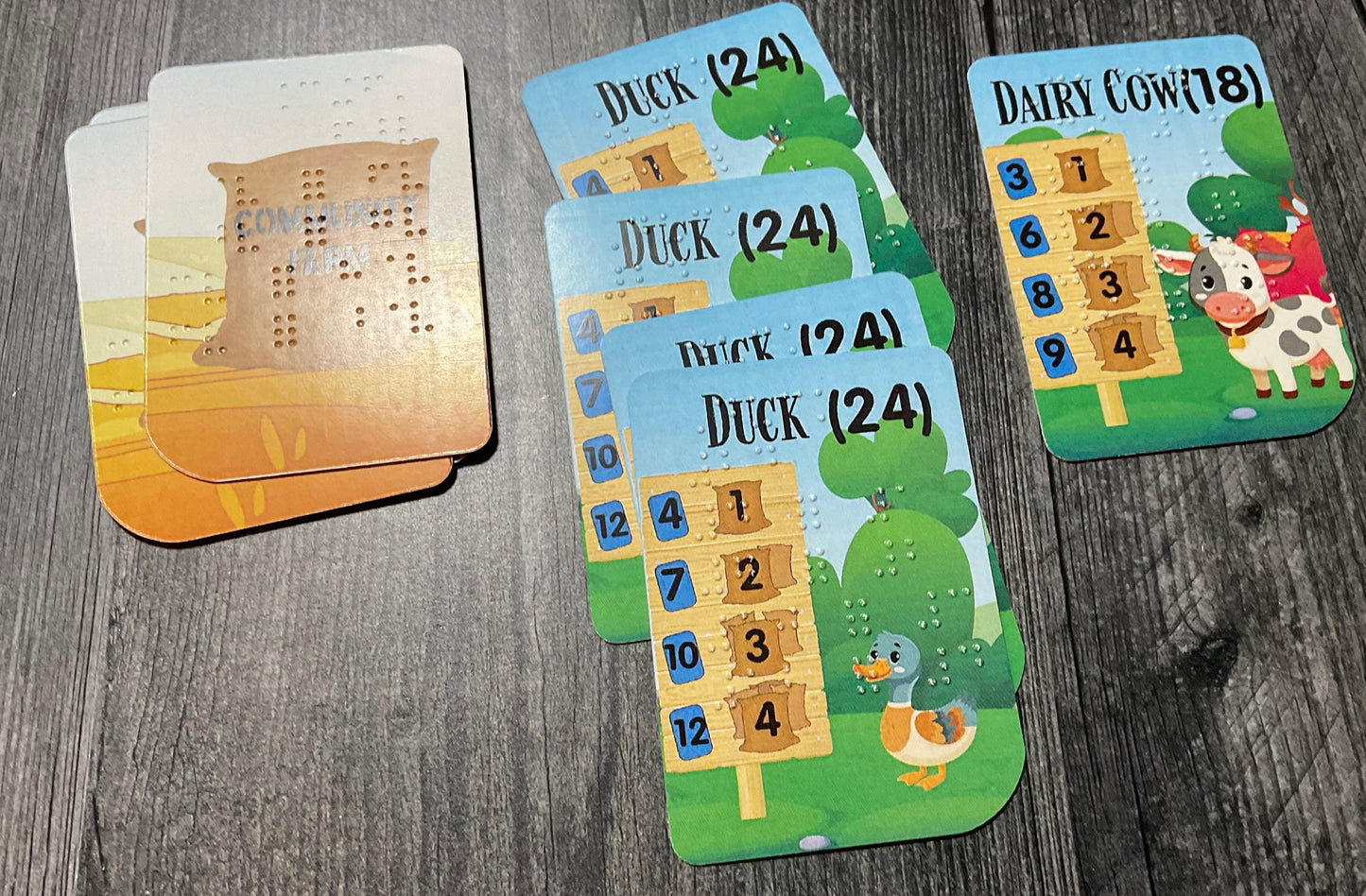 A sample stables from a player showing a player collecting ducks and dairy cows in their stables. Previously scored cards are to the left of the stables.
