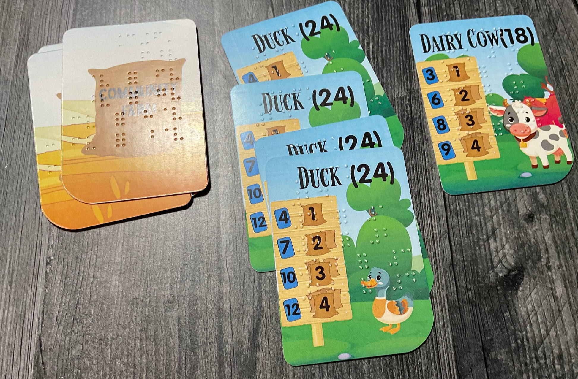 A sample stables from a player showing a player collecting ducks and dairy cows in their stables. Previously scored cards are to the left of the stables.