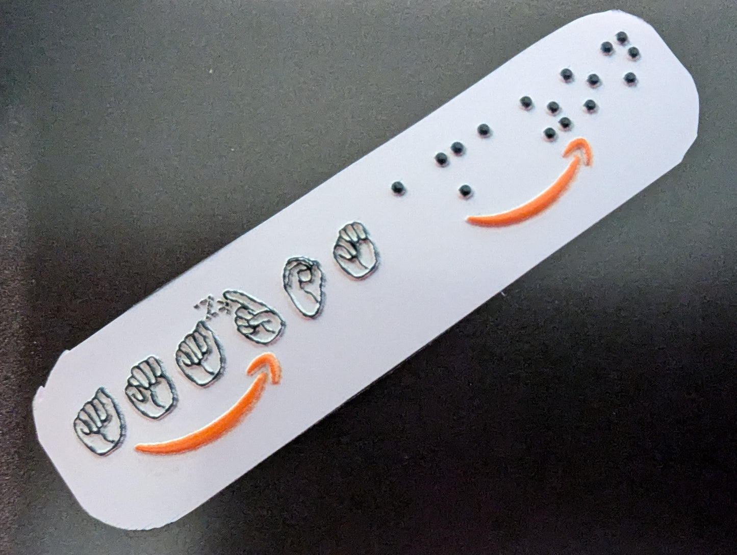 sticker with embossed Amazon logo on a dark background