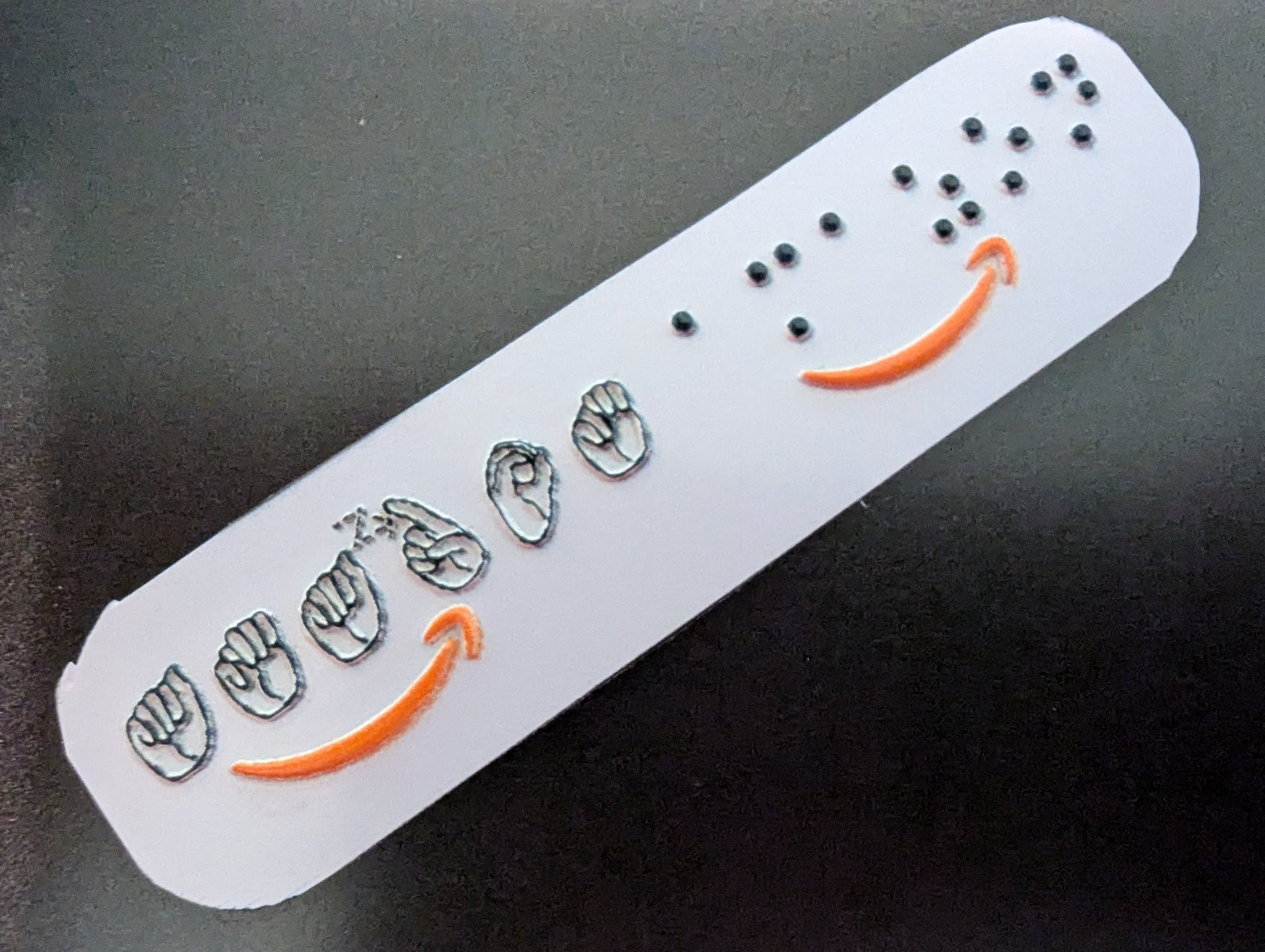 sticker with embossed Amazon logo on a dark background