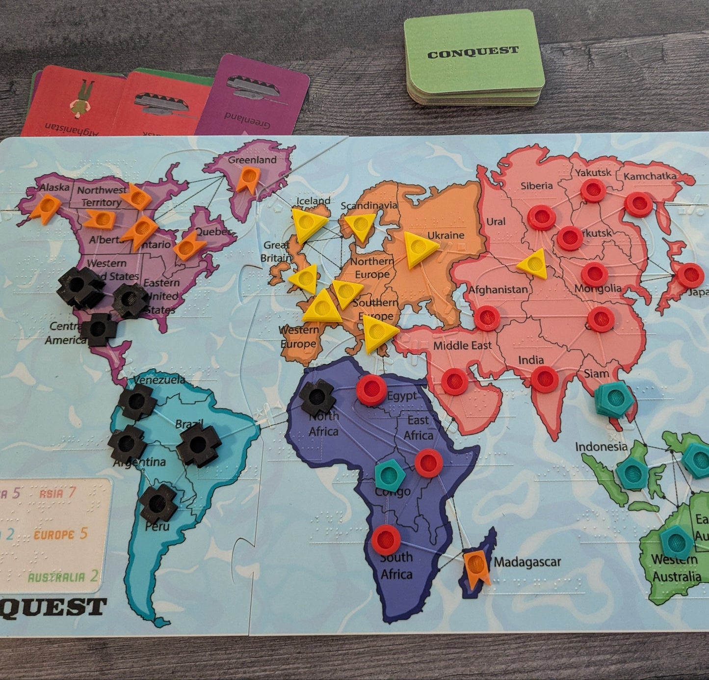 Board game map of the world with colorful markers on a wooden surface