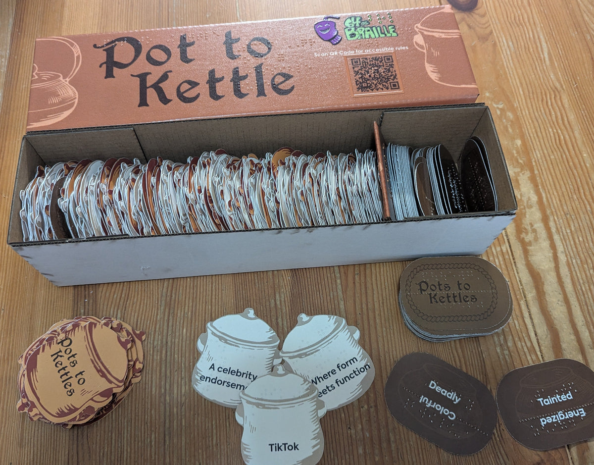 Pot to Kettle box is on the table with a few of the two types of cards stacked below it.