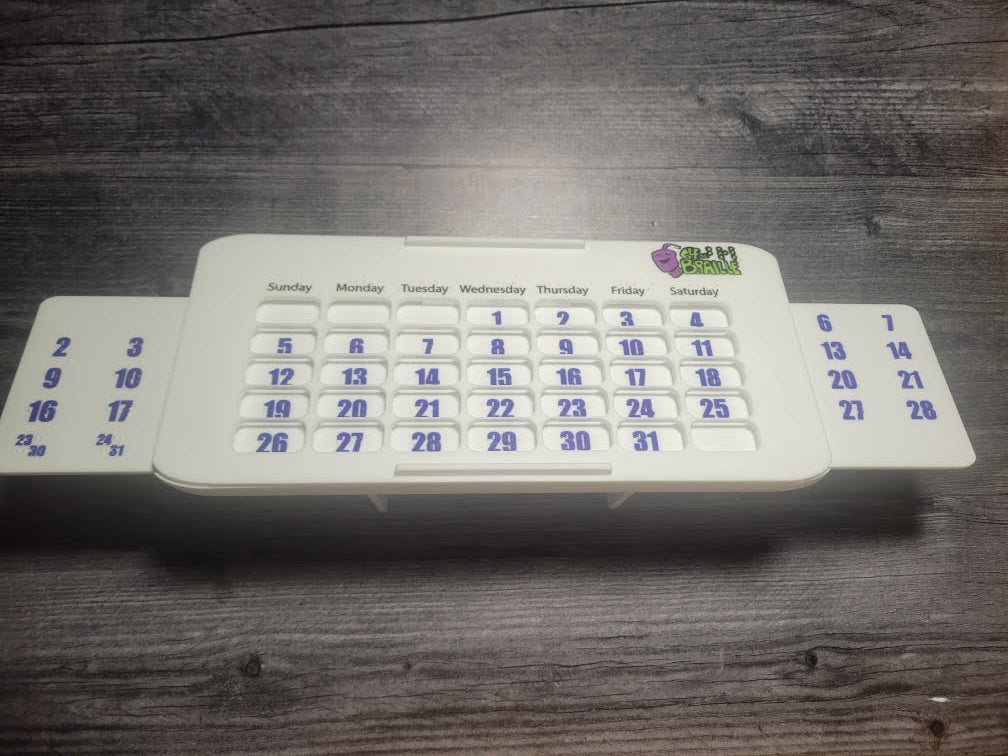 perpetual calendar sitting with it's back on the desk showing the full length of the calendar.